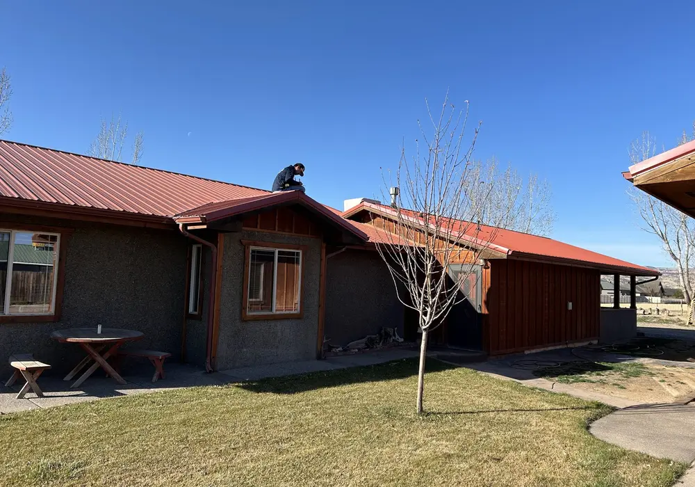 Red metal roof on a single-story home in Grand Valley